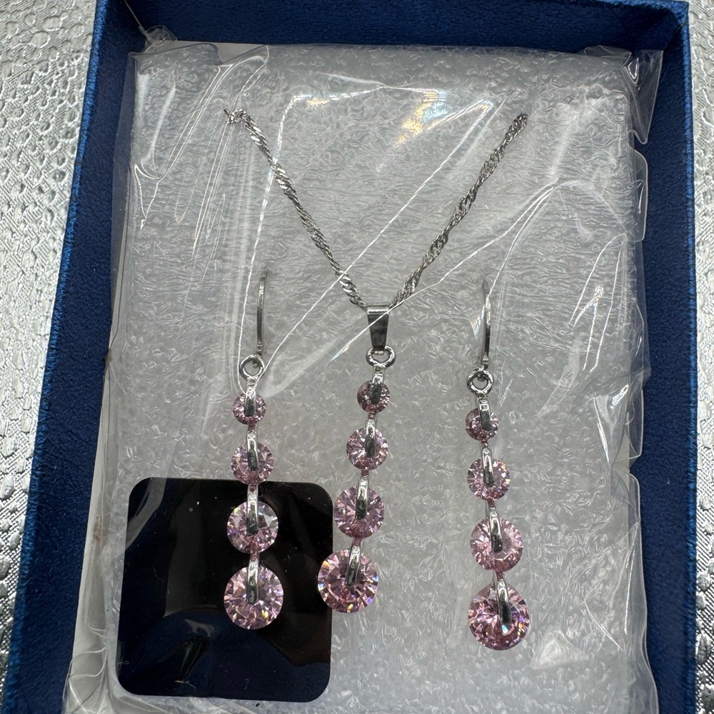 silver-toned necklace three-stone pendant matching three-stone dangle earrings.